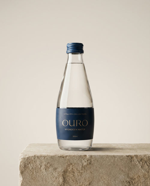 Ouro Hydrogen Water, 300ml glass bottle on a stone plinth